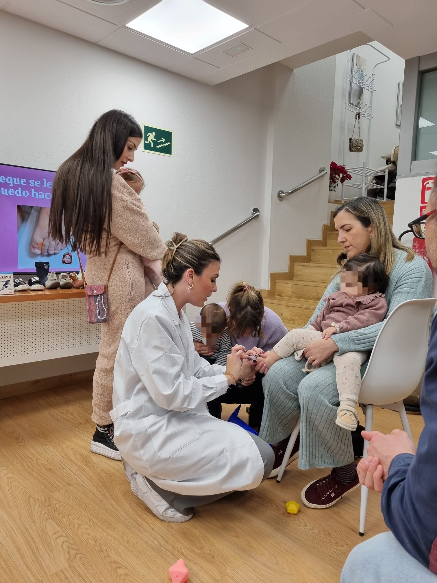 Laura en un taller presencial atendiendo a varias familias con niños